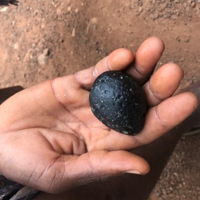 Tectite weighing 96 grams in the hand of its discoverer in Côte d'Ivoire. P.Rochette